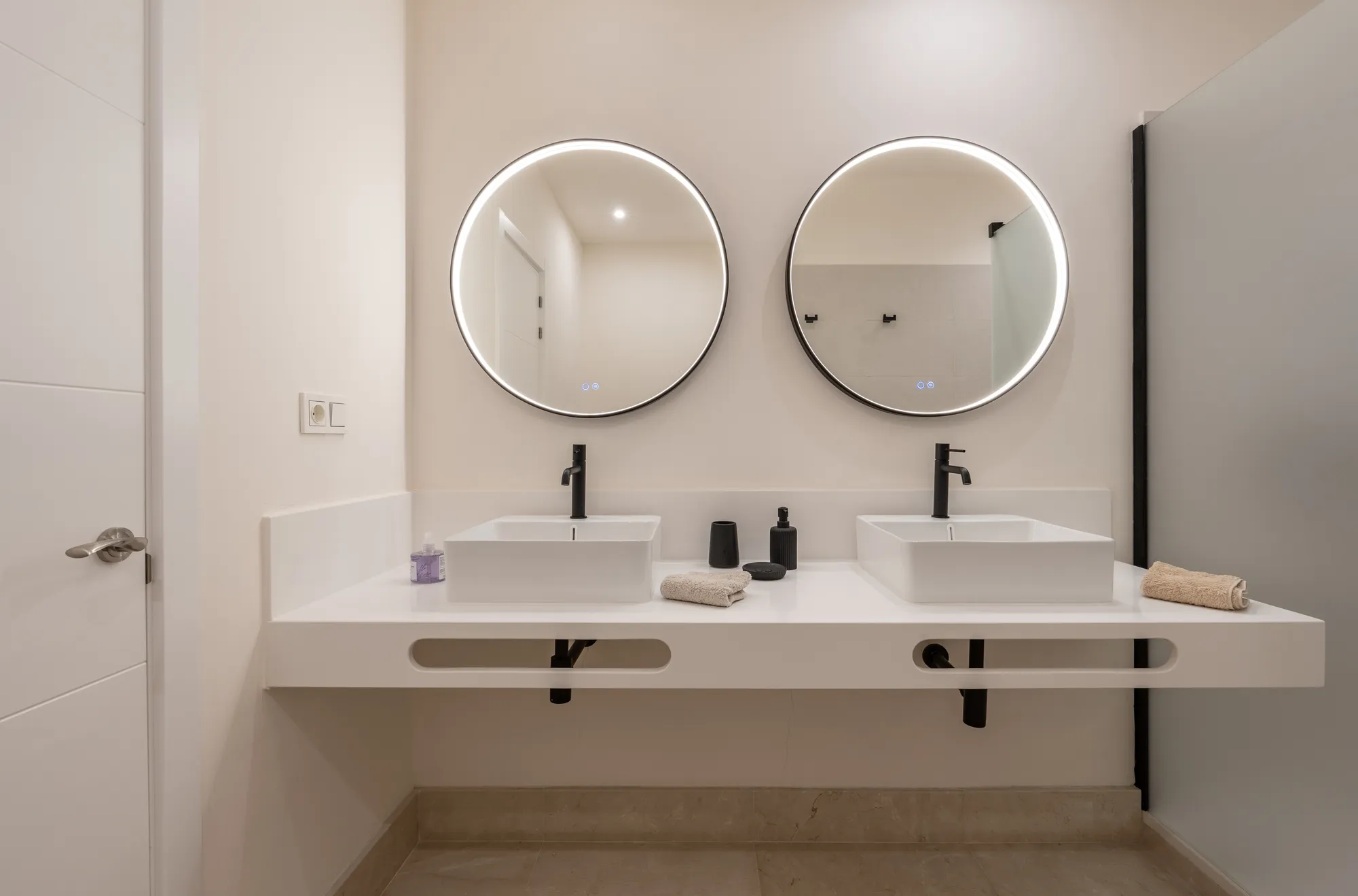 Baño en suite con doble lavabo y espejos retroiluminados